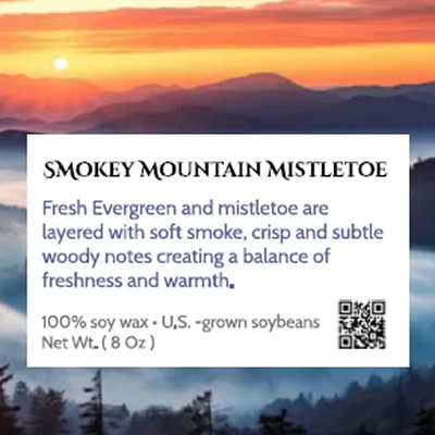 A scented candle with a Smokey Mountain Mistletoe fragrance and a sunset background.
