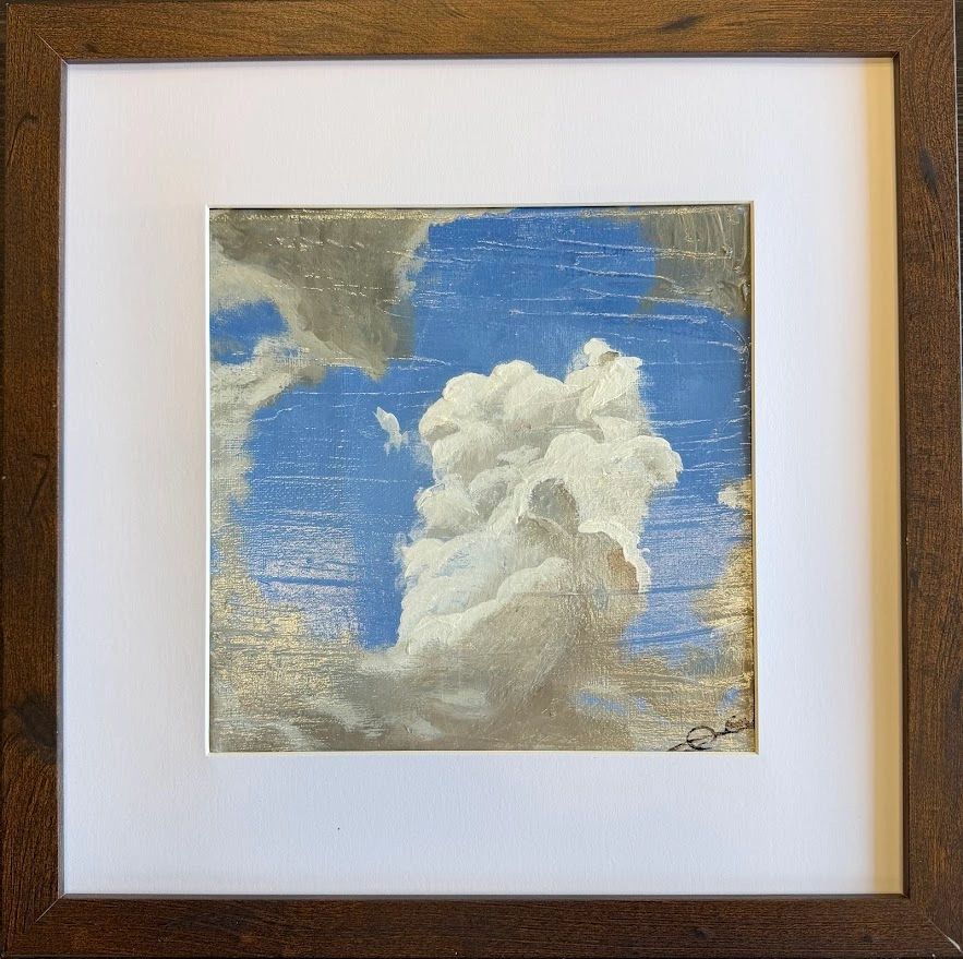 Framed artwork featuring a vintage-style cloudy sky with text.